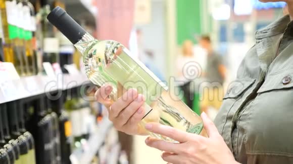 人在酒类部门超市的柜台上选择酒精饮料4k慢镜头视频的预览图