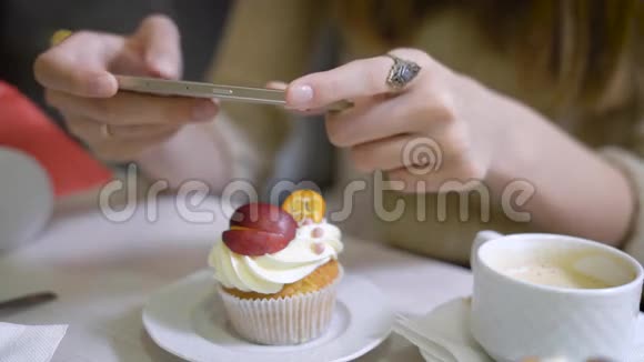 女人的手她的咖啡坐在社交网络的咖啡馆里拍照咖啡店的桌子上有视频的预览图
