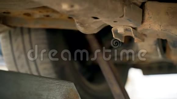 检查坑内一名汽车技工用扳手拧开汽车上的螺栓弯曲和脚趾的调整汽车视频的预览图