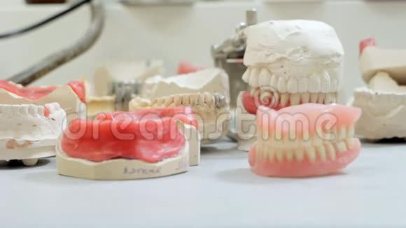 牙医假牙师从工作台上取下假牙视频的预览图