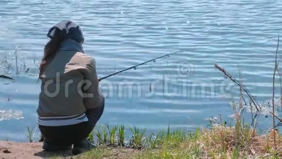 在温暖的春天女人在池塘上钓鱼视频的预览图
