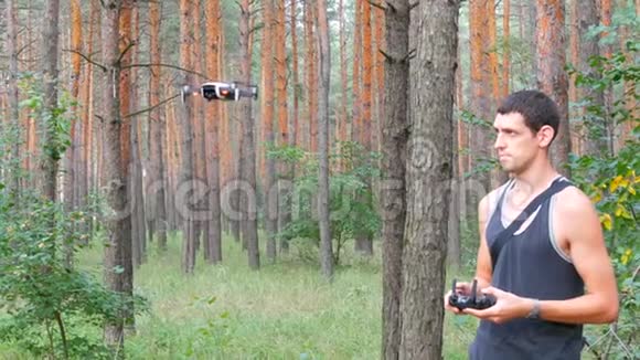 可爱的高个子男人在树林里发射无人机或四架直升机视频的预览图