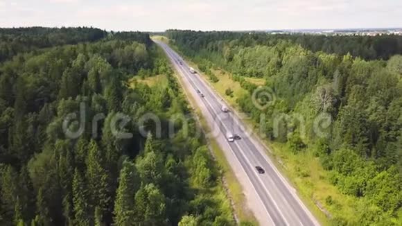 在乡间道路上驾驶汽车穿过森林的鸟瞰图一杯驶过森林道路的汽车视频的预览图