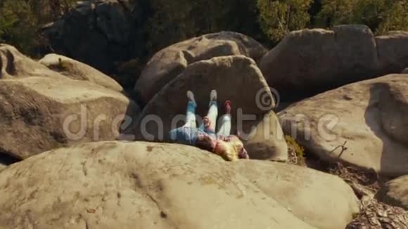 一对年轻夫妇躺在危险的修道院旁的山石上很棒的约会永远的爱快乐视频的预览图