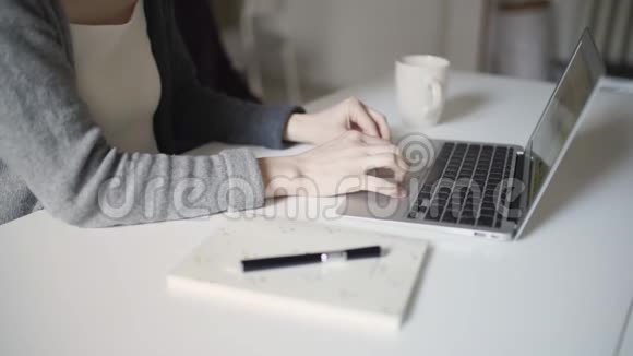 坐在桌子上的女人手在键盘上打字视频的预览图