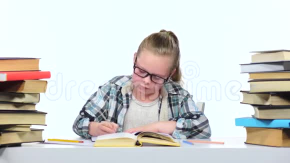女孩坐在桌子旁翻阅着书白色背景视频的预览图