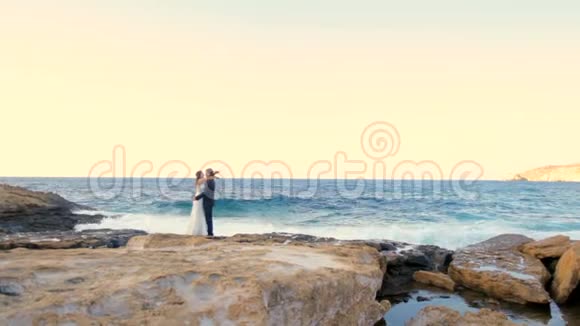 新婚之日幸福的新娘和新郎温柔地拥抱在海滨视频的预览图