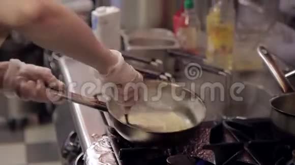 厨师在餐厅厨房里用煤气火焰准备意大利面视频的预览图