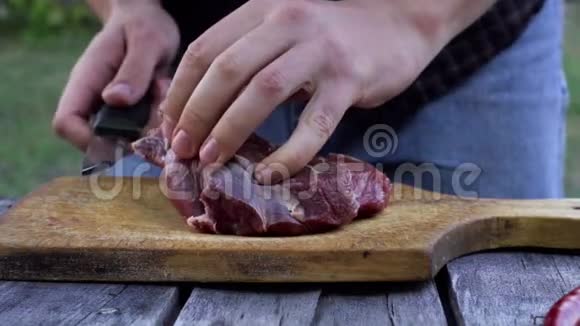 人们在后院把肉切成牛排慢动作射击视频的预览图