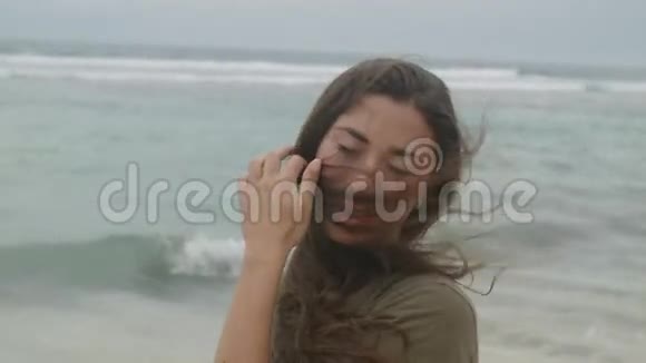 美丽的黝黑女孩长发矗立在沙滩上视频的预览图
