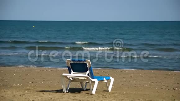 在美丽的野生沙滩上提供一张躺椅和蓝色海景没有人旅游目的地概念视频的预览图