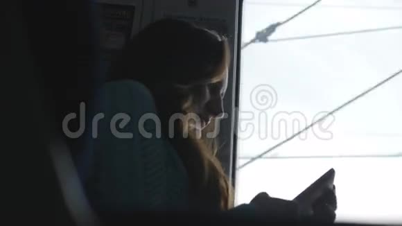 年轻女孩在坐火车时打电话女人在铁路上旅行在智能手机上说话女性视频的预览图