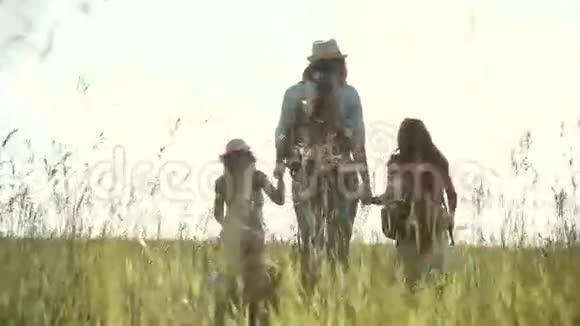 母亲和孩子们正在草地上散步家庭在户外的时间两个小女孩和她们一起露营视频的预览图