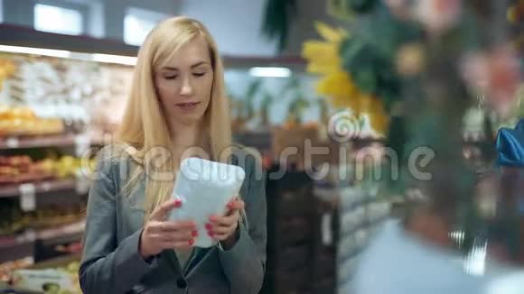 金发女人在超市持有产品视频的预览图