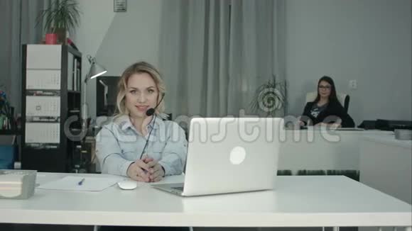 两个微笑的女人在呼叫中心接电话视频的预览图