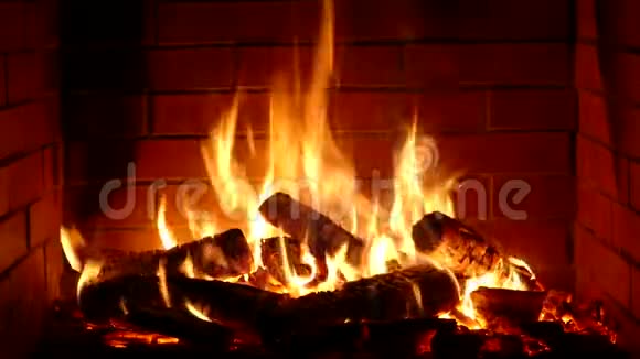 在舒适的砖制壁炉氛围中用橙色火焰慢慢燃烧的木头令人非常满意视频的预览图