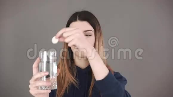 一个女孩拿着一个玻璃杯里面有溶解的平板电脑头痛缓解概念及维生素水视频的预览图