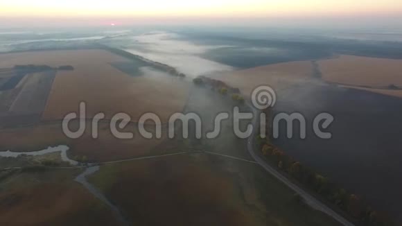 农场和陆地日落覆盖在雾中鸟瞰视频的预览图