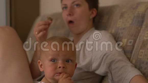 母亲和儿子吃肉看电视视频的预览图