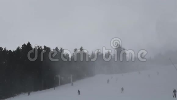 人们在山腰滑雪滑雪者沿着雪坡走焦点外的背景是山坡与下降视频的预览图