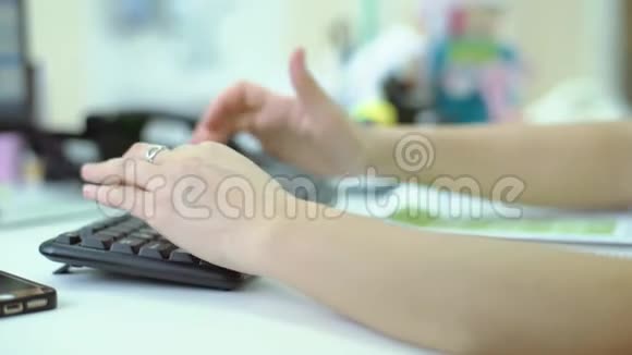 医生在他办公室的电脑上工作女性双手特写推电脑鼠标双手特写打字视频的预览图