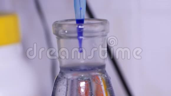 把蓝色溶液混合在实验室的烧瓶里视频的预览图