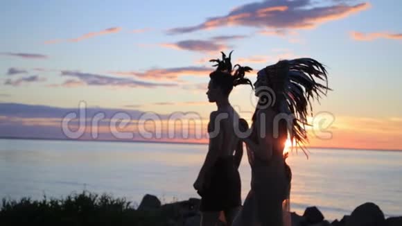 日落时分在海边慢跑的男女跑步剪影美洲土著服装和配件视频的预览图