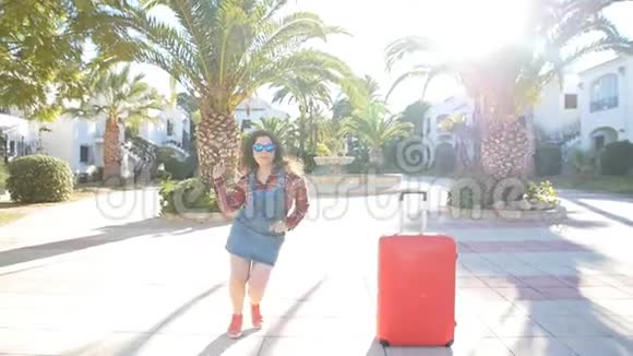 度假村附近摆手提箱的年轻女子夏季生活方式画像视频的预览图
