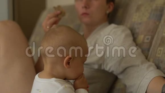 母亲和儿子吃肉看电视视频的预览图