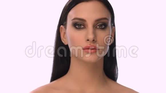 年轻漂亮的女人在白色背景上很近的脸视频的预览图