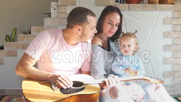 年轻漂亮的家庭花时间在厨房父亲弹吉他视频的预览图
