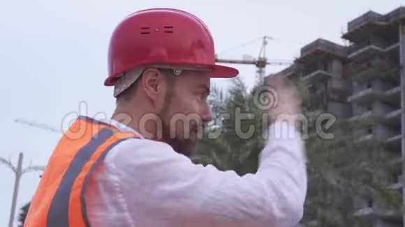 戴头盔的人建筑师工程师经理在晚间讲述施工进度视频的预览图