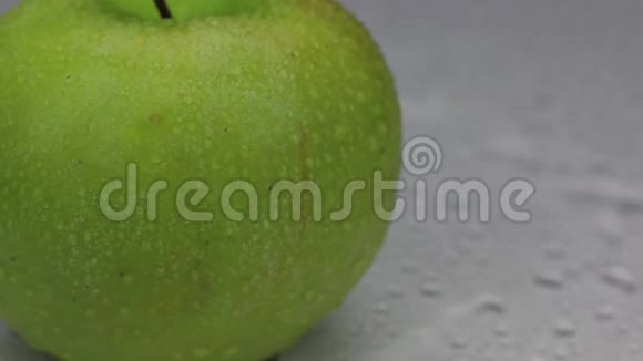 风吹走了旋转的绿色苹果上的水滴视频的预览图