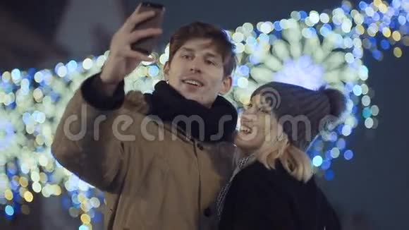 年轻的幸福夫妇在户外做冬天的自拍视频的预览图