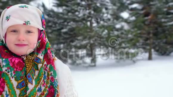 雪和森林背景下一个穿着乌尔斯风格头巾的小女孩的肖像视频的预览图