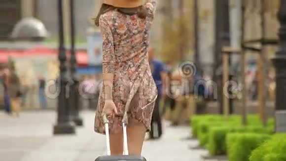 穿着优雅服装戴太阳镜戴帽子走路的女游客视频的预览图