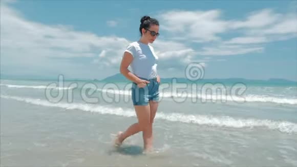穿着黑色眼镜白色衬衫和蓝色短裤的欧洲美丽的深色头发在炎热的夏季阳光下视频的预览图