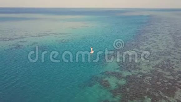 年轻女孩在度假时站起来划船的鸟瞰图跟踪一名年轻女子登机视频的预览图