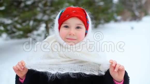 雪和森林背景下一个穿着乌尔斯风格头巾的小女孩的肖像视频的预览图