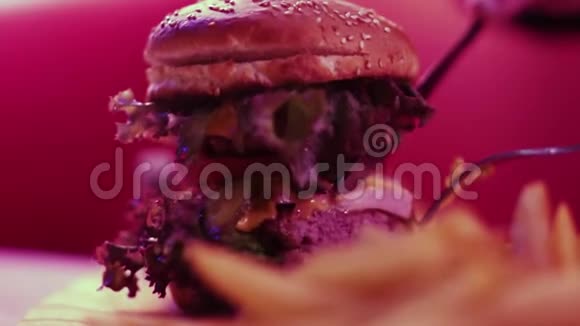 提供新鲜美味的汉堡和炸薯条木制桌子高清视频的预览图