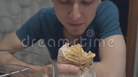 一个年轻人非常饥饿急切地吃着围巾视频的预览图
