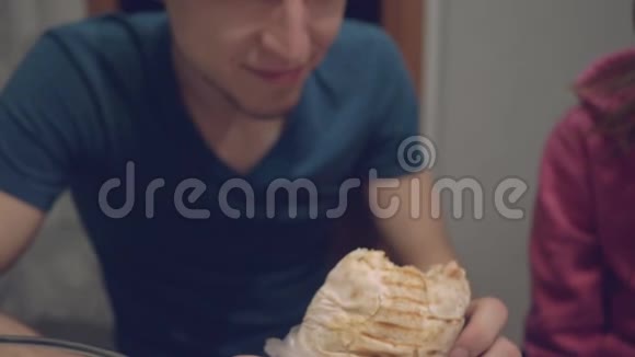 一个年轻人非常饥饿急切地吃着围巾视频的预览图