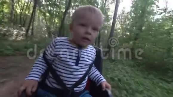 小男孩坐在自行车椅上一边开车一边环顾四周视频的预览图