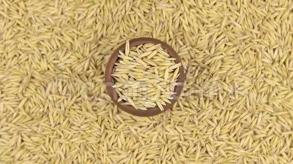 旋转和接近燕麦在一个粘土锅站在燕麦种子的背景视频的预览图