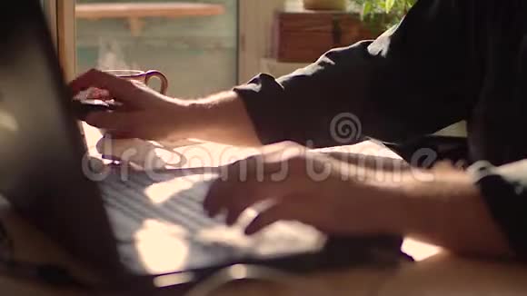 一个人在用笔记本电脑他喝热茶专注于一杯茶视频的预览图