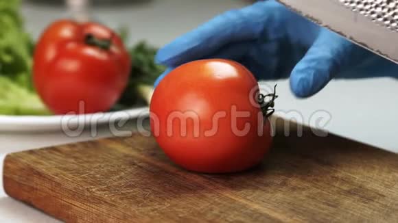 用刀子把手套上的手切成熟番茄视频的预览图