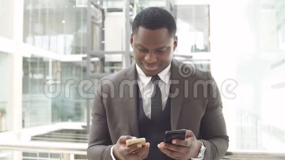 非裔美国商人在智能手机上阅读电子邮件并发短信回答视频的预览图