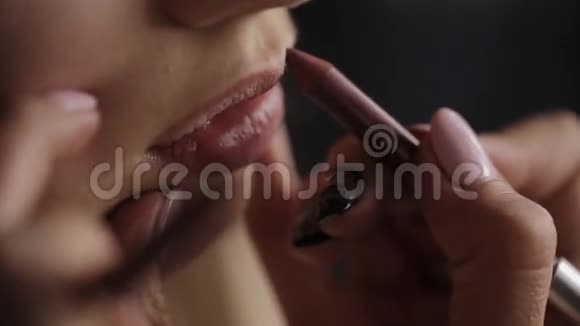 化妆师为女孩画嘴唇模特的专业化妆美丽的新娘化妆视频的预览图