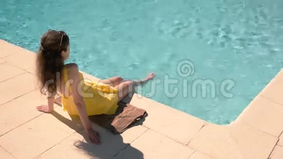 坐在游泳池附近的女人视频的预览图
