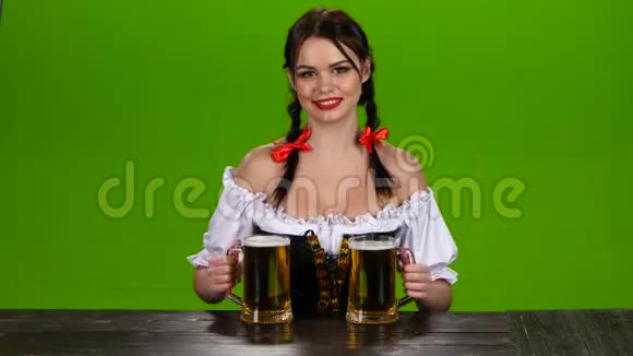 身着巴伐利亚服装的女士提供两杯啤酒绿色屏幕视频的预览图
